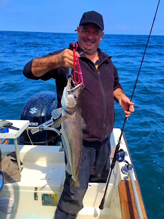 Pêcheur posant avec un  merlu capturé lors d’une sortie de pêche multi espèces découverte au Pays Basque