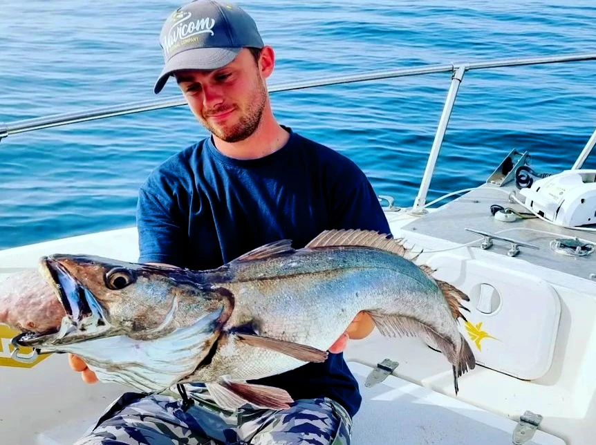 Pêcheur posant avec un gros merlu capturé lors d’une sortie de pêche multi espèces au Pays Basque
